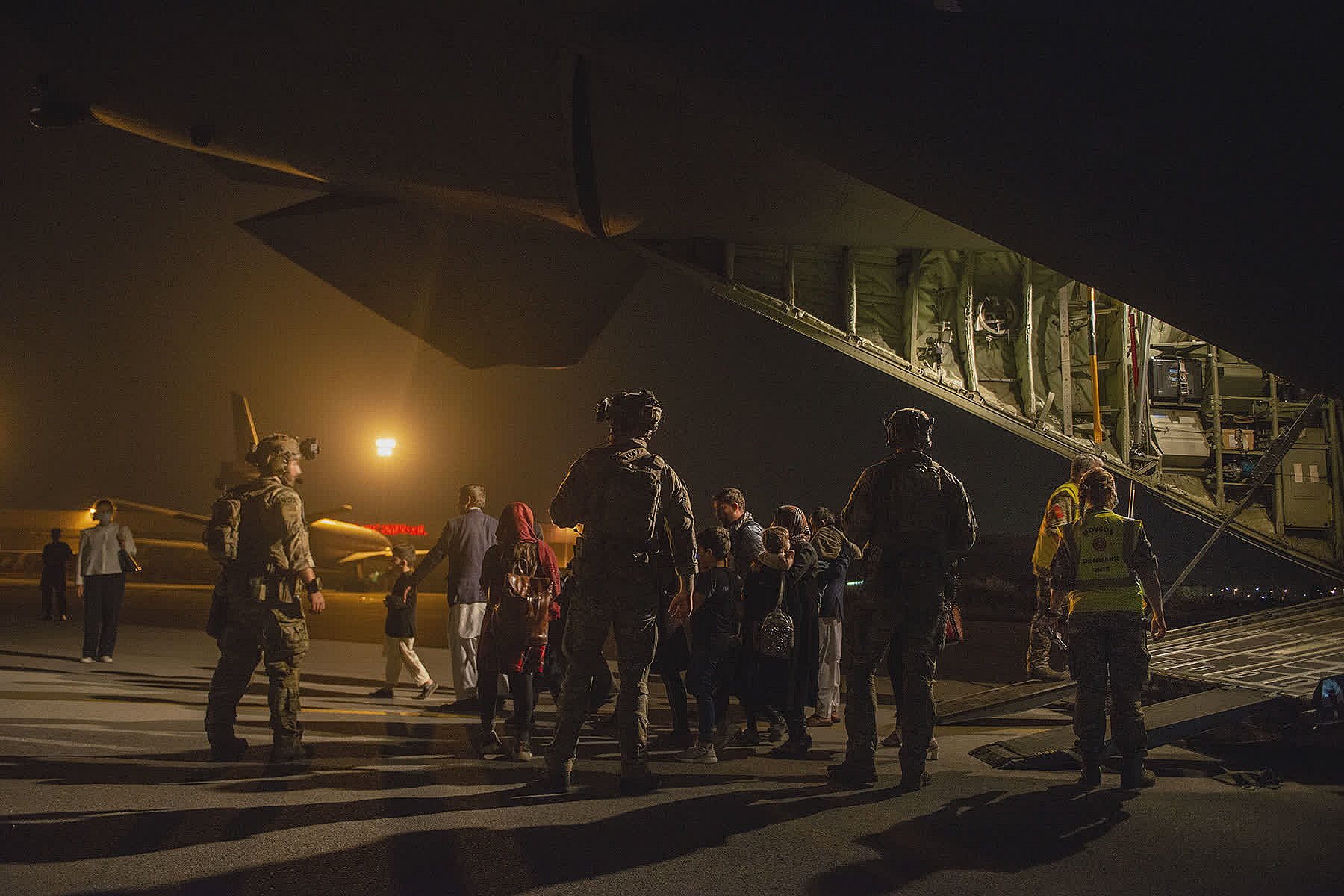 Flygtninge på vej ud af flyveren i lufthavnen i Islamabad.