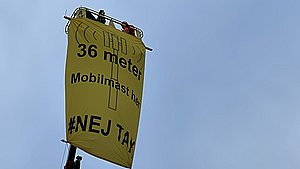 Vrede naboer i oprør: Hejser sig 36 meter op i en kran i protest mod telemast